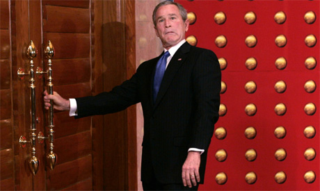 Bush laget en spøkefull grimase da han møtte en stengt dør etter en pressekonferanse i Beijing i dag. (Foto: Scanpix / AP)