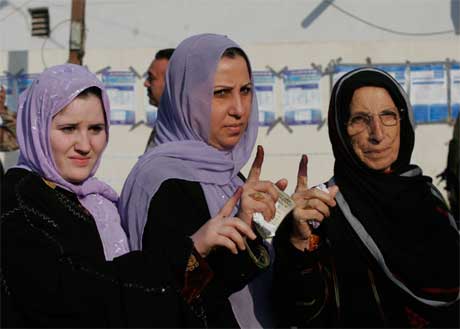 Velgere i Bagdad viser frem blekket på fingrene som tegn på at de har stemt. (Foto: Samir Mizban/ AP/ Scanpix)