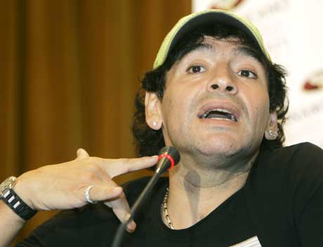 Diego Maradona viser hvor den brasilianske politimannen angivelig skal ha holdt pistolen mot ham på flyplassen. (Foto: AP/Scanpix)