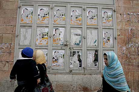 Palestinske kvinner går forbi ødelagte valgplakater i Øst-Jerusalem. Foto: AFP/Scanpix