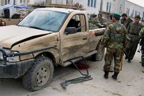 Soldater sjekker stedet fire mennesker ble drept i en bombeeksplosjon i Kandahar. (Foto: Noor Khan/ AP/ Scanpix)