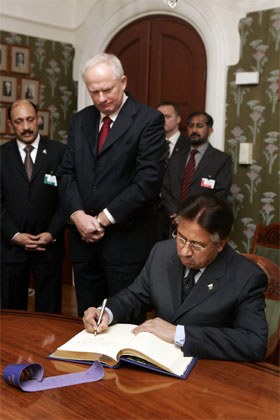 Pakistans president Pervez Musharraf skriver seg inn i gjesteboken under møtet med Nobelinstituttets direktør Geir Lundestad i Nobelinstituttet i Oslo. (Foto: Heiko Junge/Scanpix)
