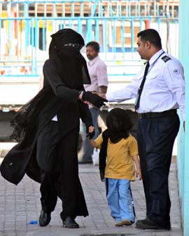 Michael Jackson ikledd en såkalt abaya blir mottatt av en vakt på senteret. (Foto: H.Mohammed, Reuters) 