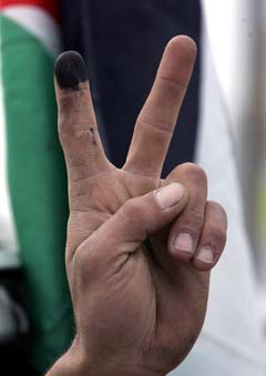 En palestiner som har stemt viser V-tegnet i Anata på Vestbredden. (Foto: M.Kahana, AFP)