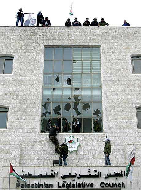 Væpnede Fatah-tilhengere reiser det palestinske flagget på taket av parlamentsbygningen i Ramallah på Vestbredden. (Foto: AFP/Scanpix) Væpnede Fatah-tilhengere reiser det palestinske flagget på taket av parlamentsbygningen i Ramallah på Vestbredden. (Foto: AFP/Scanpix)