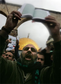 En palestiner roper mens han holder opp Koranen foran Al-Aqsa moskeen i Jerusalem. Foto: AFP Photo
