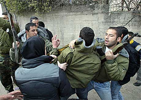 Palestinske sikkerhetsstyrker tar hånd om en av de steinkastende ungdommene.(Foto:Reuters/Scanpix)