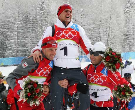 OL-kongen Michael Greis løftes på gullstol av Tomasz Sikora og Ole Einar Bjørndalen etter fellesstarten. (Foto: Reuters/Scanpix)