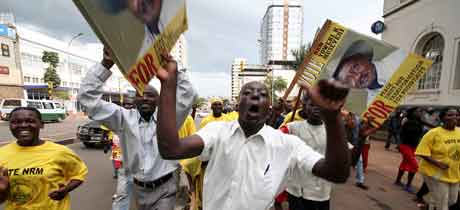 Tilhengere av Museveni løper gjennom gatene i Kampala. Foto: Stuart Price, AFP