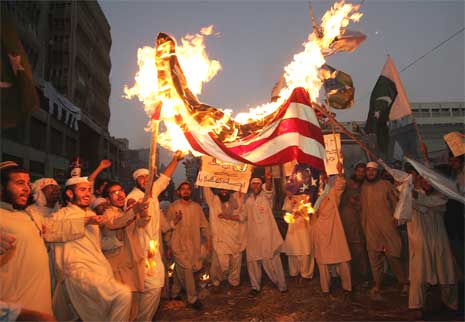 Demonstrantene ropte slagord og brente flagg i Karachi i Pakistan i dag, i protest mot Muhammed-tegningene. (Foto: Reuters/Scanpix)