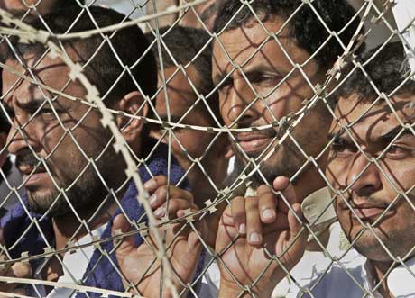 Fanger innenfor piggtråden i Abu Ghraib-fengslet. Nå skal det legges ned. Foto: Scanpix/AFP.