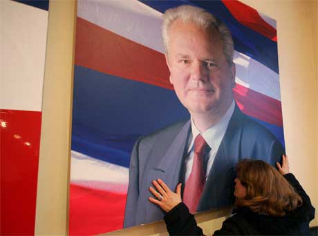 En tilhenger kysser bildet av Slobodan Milosevic i Beograd i dag. Foto: AP/Scanpix