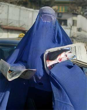 En afghansk kvinne selger aviser i en gate i Kabul. (Foto: Ap Photo, Rafiq Maqbool)