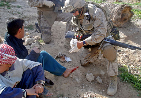 <b>Kamp om opinionen:</b> Dette bildet sendte de amerikanske styrkene i Irak ut i dag. Det viser en soldat som hjelper en iraker med plaster. (Foto: USAs militre styrker/AFP/Scanpix)