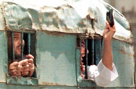 Islamister vinker med Koranen mens de blir brakt til fengsel etter angrepet i Luxor i 1997 (Scanpix/AFP)