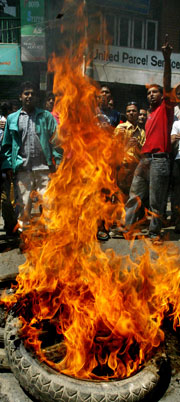 Demonstrantene danset rundt brennende bildekk mens de ropte slagord mot kongen. (Foto: Scanpix/AP)