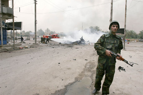 En soldat sikrer området etter en eksplosjon i Bagdad i dag. (Foto: AP/Scanpix)