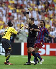 Emmanuel Eboue ber om å få slippe kort, men Terje Hauge var nådeløs. I bakgrunne ser Ronaldinho på. (Foto: AP(Scanpix)