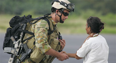 En australsk soldat tar en øst-timorsk dame i hånden etter å ha landet på flyplassen i Dili (Foto: AP/Scanpix)