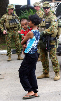 En mor bærer barnet sitt forbi australske soldater i Øst-Timor. Håpet er at de utenlandske styrkene vil kunne stabilisere situasjonen i det fattige landet. Foto: Reuters/Lirio Da Fonseca En mor bærer barnet sitt forbi australske soldater i Øst-Timor. Håpet er at de utenlandske styrkene vil kunne stabilisere situasjonen i det fattige landet. Foto: Reuters/Lirio Da Fonseca