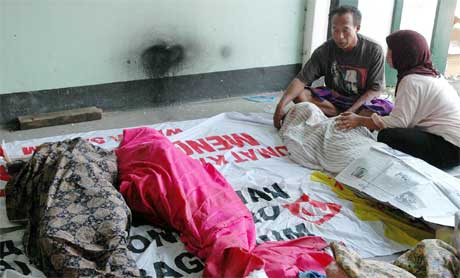 Familiemedlemmer sørger over døde slektninger etter jordskjelvet på Java i natt. (Foto: AFP/Scanpix)