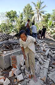 En eldre kvinne beveger seg gjennom ruinene etter jordskjelvet i byen Yogyakarta i Indonesia. (Foto: AFP/Scanpix)