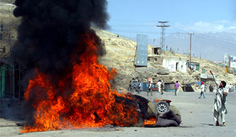 En afghansk protestant kaster stein mot politiet. Foto: AP Photo/Xinhua, Zabi Tamanna En afghansk protestant kaster stein mot politiet. Foto: AP Photo/Xinhua, Zabi Tamanna