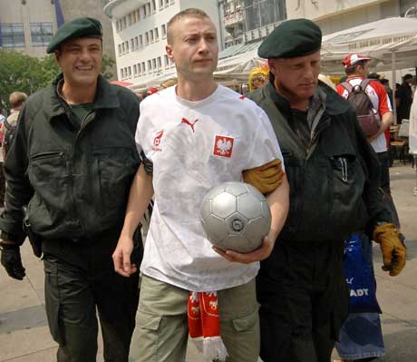 En polsk supporter i Dortmund flankert av to tyske politimenn. (Foto: AFP/Scanpix)