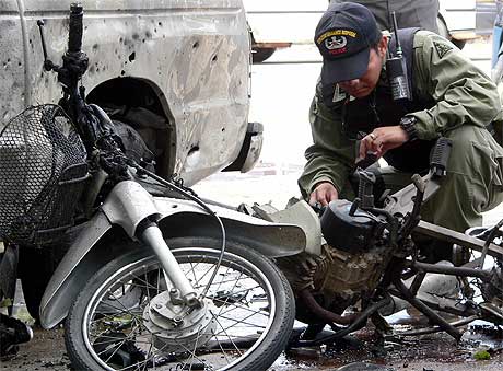 SMELLER: En politimann sjekker åstedet for en av bombene som gikk av i provinsen Pattani Foto: AFP/Scanpix.