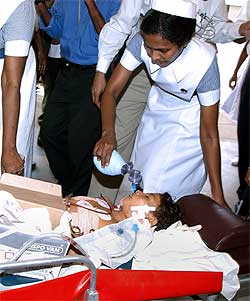 SÅRET: Den 10 år gamle jenta Pavithra overlevde og hjelpes av en sykepleier. Foto: AFP/Scanpix.