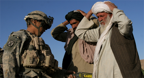En amerikansk soldat kontrollerer to sivile afghanere i en landsby. Situasjonen i landet har blitt mer utrygg, skriver NRKs kommentator. (Foto: AP, Scanpix)