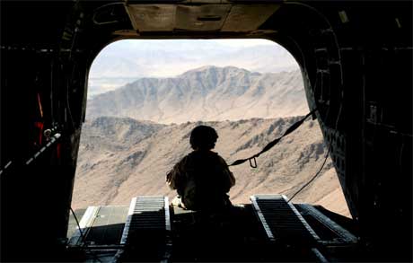 En amerikansk soldat ser ut fra et helikopter over Helmand-provinsen. På bakken er over 100 mennesker drept i kamper de siste tre dagene. (Foto: Rodrigo Abd/ AP/ Scanpix)