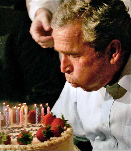 Mission accomplished: Vi vet ikke om bildene er tatt samtidig, eller om Bush ble sittende på denne måten utover kvelden. (foto: Scanpix / AFP) 