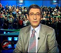 Programleder Mikhail Osokin under kveldssendingen på NTV tirsdag 3. april 2001. I bakgrunnen sitter hans journalistkolleger ved den truede tvstasjonen. (Arkivfoto: Scanpix/Reuters)