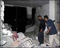 Palestinske sikkerhetsoffiserer undersøker en bygning som ble ødelagt av israelske raketter onsdag 16. mai 2001 ved Jabalia-flyktningeleiren. (Foto: Scanpix/EPA/Fayez Nureldine)