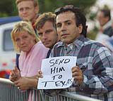"Send ham til Texas", står det på plakaten som en tilskuer holder foran Scheveningen-fengselet i Haag i går kveld. I natt kom Milosevic til fengselet. (Foto: Scanpix/AP/Michel Porro)